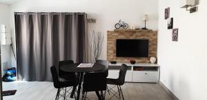 a dining room with a table and chairs and a television at Studio calme in Mitry-Mory