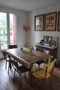 una sala da pranzo con tavolo e sedie in legno di Maison proche stade de France et village olympique a Enghien-les-Bains