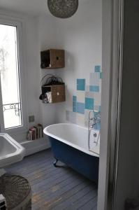 bagno con vasca e finestra di Maison proche stade de France et village olympique a Enghien-les-Bains