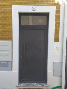 una porta nera su un edificio con un muro di mattoni di A Casa da Joana ad Aveiro