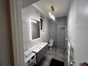 La salle de bains est pourvue d'un lavabo blanc et de toilettes. dans l'établissement Neversea Suite, à Constanţa