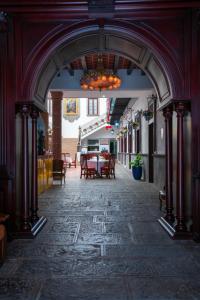 HOTEL MARGARITA في بوبلا: ممر في مبنى مع طاولة وكراسي