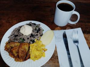 un plato de comida y una taza de café sobre una mesa en Cabaña blue jeans, en San Ramón