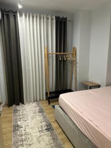 1 dormitorio con 1 cama y algunas cortinas en Centrally located Glamorous Bright APT near Bazaar, en Tirana