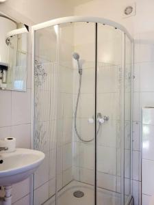 una ducha con una puerta de cristal junto a un lavabo en Apartman Starý Liskovec, en Brno