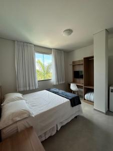 Un dormitorio con una gran cama blanca y una ventana en Hotel Penedo Inn en Penedo