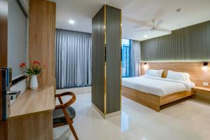 Habitación de hotel con cama y TV en Harvey's Hotels (Gachibowli) en Hyderabad