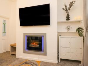 a living room with a fireplace with a flat screen tv at Kitty Cottage in Blackpool