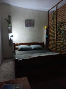 a bedroom with a bed with a wooden head board at Dvorska oaza in Sremski Karlovci
