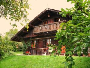 Cette maison en bois dispose d'un balcon au-dessus d'une cour. dans l'établissement Le Doubs Chalet - Chalet Garnache, à Oye-et-Pallet