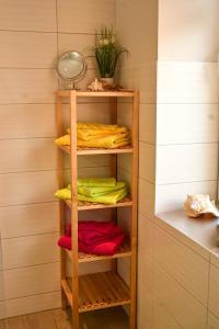 a closet with colorful towels on a wooden shelf at Fewo Pöhlbergblick Wolkenstein in Wolkenstein
