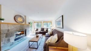 a living room with a couch and a fireplace at Powderhorn by Whistler Premier in Whistler