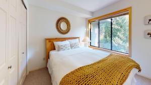 a bedroom with a large white bed and a window at Powderhorn by Whistler Premier in Whistler