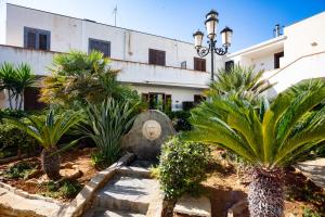 a courtyard with palm trees in front of a building at Casa di Marta San Vito Lo Capo in San Vito lo Capo