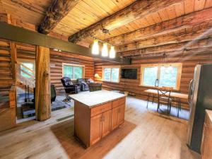 una gran sala de estar con paredes de madera y suelo de madera. en Wilderness Vista Retreat, en Reed City