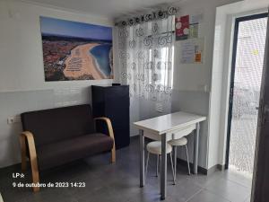 een wachtkamer met een stoel en een tafel bij Nazaré - The Little Star in Nazaré