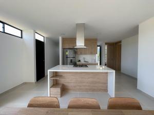 a kitchen with a white counter and some chairs at Casa Sentido - Tu refugio campestre in Alvarado