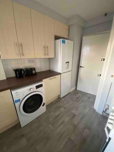 a kitchen with a washing machine and a refrigerator at Kenton Apartment- Wembley links in Harrow Weald