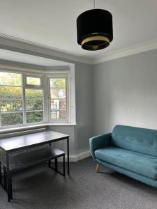 a living room with a blue couch and a table at Kenton Apartment- Wembley links in Harrow Weald