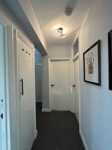 a hallway with a white door and a hallway with a hallwayngth at Kenton Apartment- Wembley links in Harrow Weald