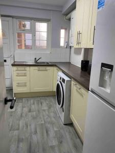 een keuken met een wasmachine en een wasmachine. bij Kenton Apartment- Wembley links in Harrow Weald