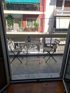 Cozy 2 Bedroom apt @Panormou Metro/Erytros Stavros في أثينا: اطلاله بلكونه مع طاوله وكراسي
