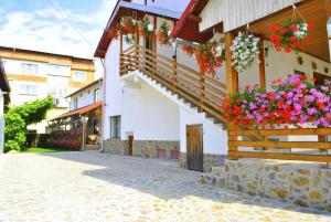 a building with flowers on the side of it at Pensiunea Ruxi in Curtea de Argeş