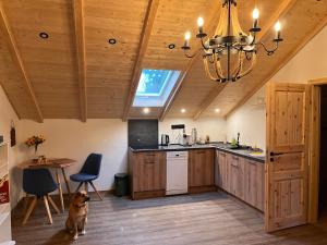 a dog sitting in a kitchen with a chandelier at Romantische Game Changer Hof Suite in Eging