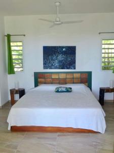 a bedroom with a large bed and two windows at Bungalow DOUROU in Deshaies