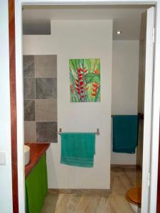 a bathroom with a green towel hanging on a wall at Bungalow DOUROU in Deshaies