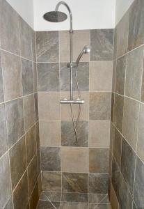 La salle de bains est pourvue d'une douche avec un pommeau de douche. dans l'établissement Bungalow DOUROU, à Deshaies