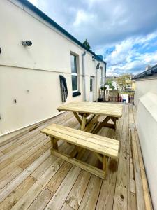 a wooden deck with a picnic table on a house at Executive apartments, nr city centre with private parking in Plymouth