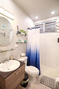 a bathroom with a toilet and a sink and a mirror at Casa Arrecife 28 in Cabo Rojo