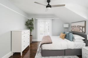 a white bedroom with a bed and a ceiling fan at Bankers Hill Chic Roomy Home Near Airport in San Diego