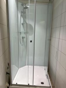 a shower with a glass door in a bathroom at SleepWell100 in Cologne
