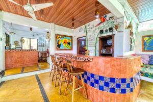 a bar in a restaurant with a counter and chairs at Hotel Tropical Sands Dominical in Dominical