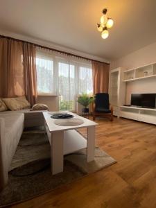 uma sala de estar com um sofá branco e uma mesa em Zawadzkiego 104 em Szczecin