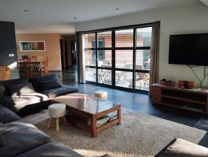 a living room with a couch and a table at VILLA KB'HOME in Le Touquet-Paris-Plage