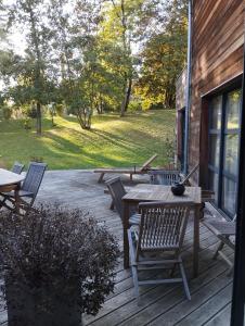 um deque de madeira com uma mesa e bancos sobre ele em VILLA KB'HOME em Le Touquet-Paris-Plage