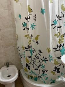 a bathroom with a shower curtain with birds on it at Habitación privada in Valencia