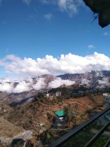 uma vista para uma montanha com nuvens ao fundo em Badrinath House by Prithvi Yatra Hotel em Badrinathpuri