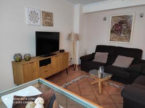 a living room with a couch and a flat screen tv at Casa Rural La Tejeria in Villora