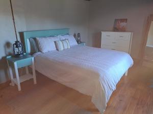sypialnia z dużym łóżkiem i stolikiem nocnym w obiekcie Old Farmhouse Cottage w mieście Kareedouw