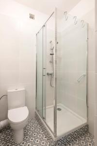 een badkamer met toilet en glazen douche bij Apartament Paparazzi in Warschau