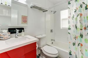 La salle de bains blanche est pourvue de toilettes et d'un lavabo. dans l'établissement Rosa- casita near beach & gym access, à Hollywood