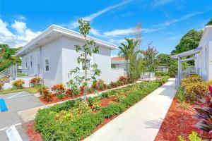 une maison blanche avec un jardin en face dans l'établissement Rosa- casita near beach & gym access, à Hollywood