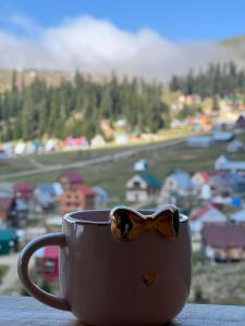 a coffee cup with a bow tie sitting on a table at Chalet Bakhmaro in Chʼkhakoura