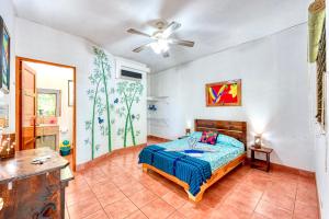 a bedroom with a bed and a ceiling fan at Hotel Tropical Sands Dominical in Dominical