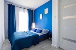 um quarto azul com uma cama e uma janela em Vip Apartament Wieniawskiego em Rzeszów