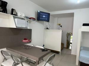 a dining room with a table and chairs and a tv at Apartamento studio térreo in Balneário Camboriú